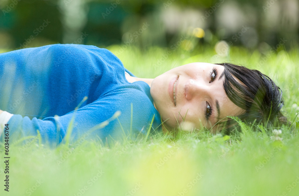 attractive woman relaxing on grass in park attractive woman relaxing on grass in park