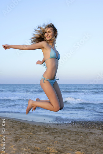 Beautiful blond girl jumping bikini on the beach © Designpics