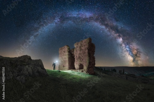 Milky Way arch over the medieval Castle of Alcaraz. A man with a lantern is watching the Milky Way over the famous medieval Castle of Alcaraz gate, Albacete, Castilla La Mancha, Spain	
