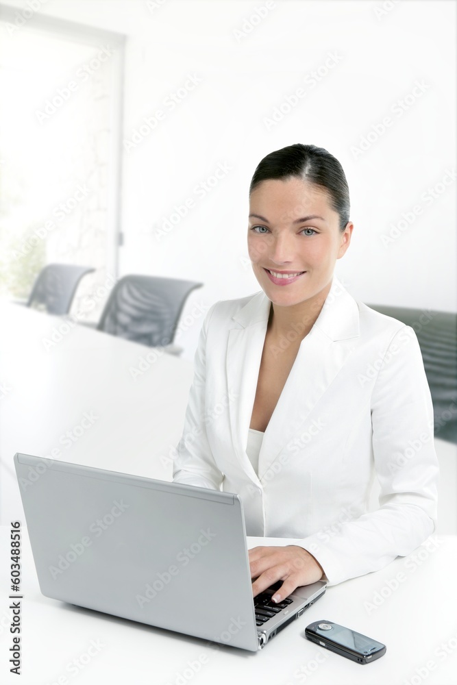 Modern businesswoman working in white office with laptop computer