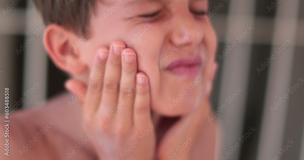 Child boy spreading sunscreen to his face. Kid applying sunblock lotion to himself Child boy spreading sunscreen to his face. Kid applying sunblock lotion to himself