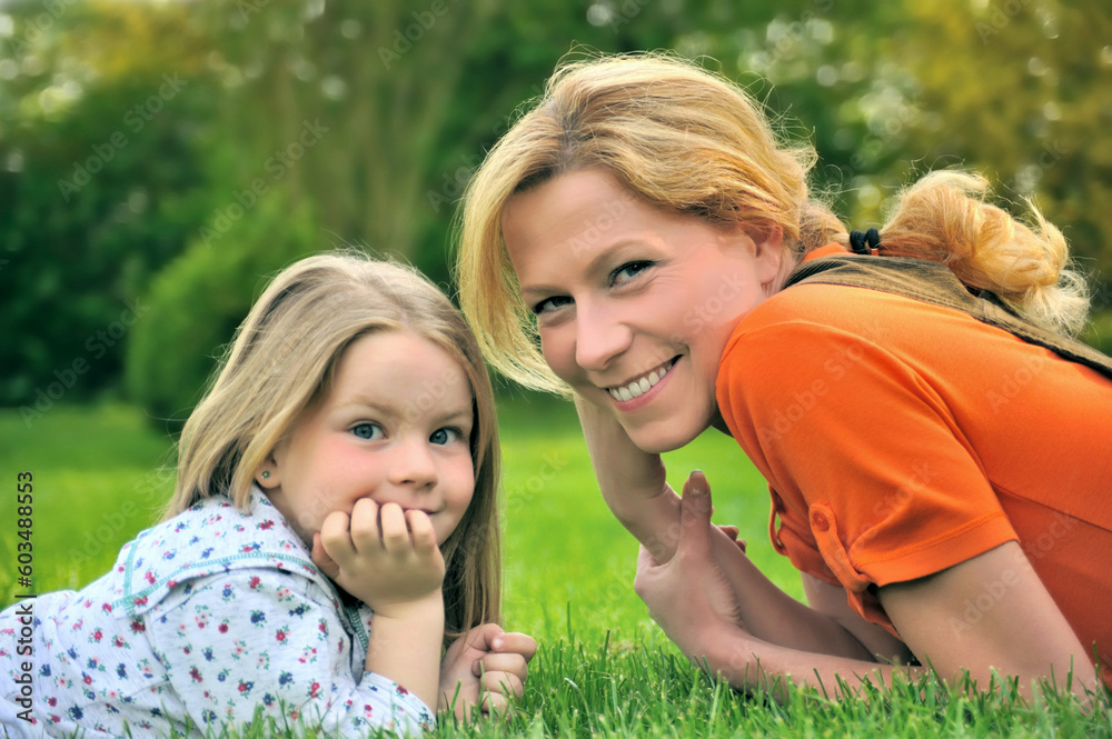 Young mother and daughter laying on the grass Young mother and daughter laying on the grass