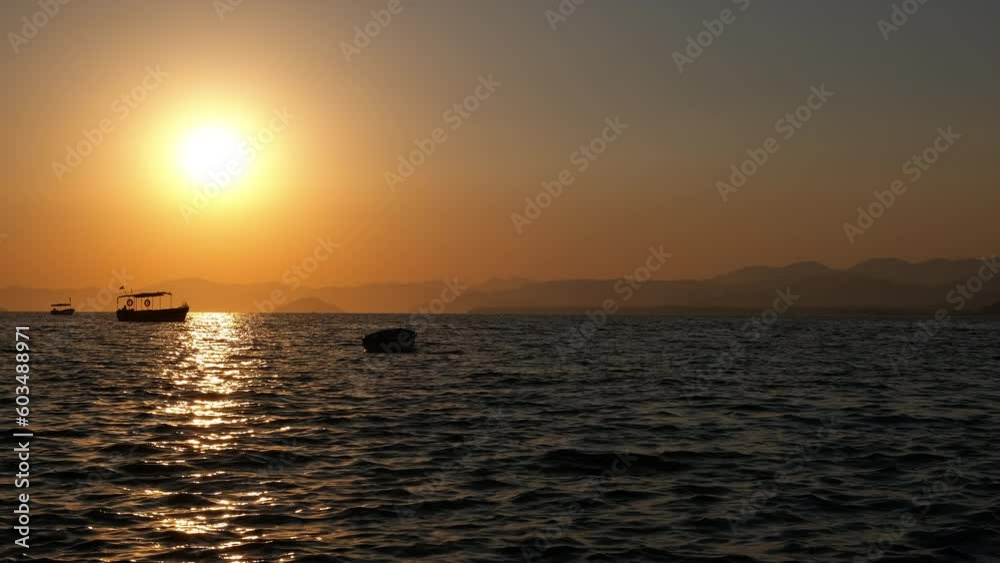 Seascape silhouette at sunset with islands and boats. Seascape silhouette at sunset with islands and boats.