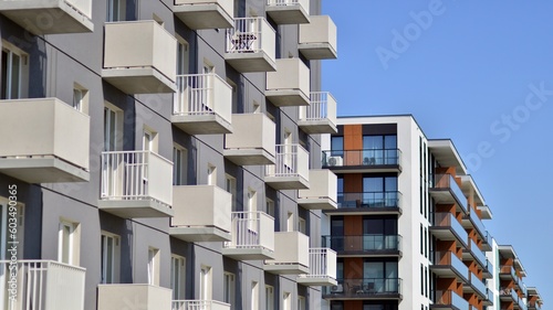 Apartment building with bright facades. Modern minimalist architecture with lots of square glass windows and balconies.