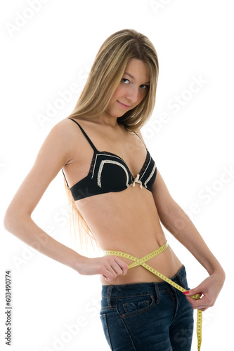 Beautiful girl measuring her waist with a measuring tape