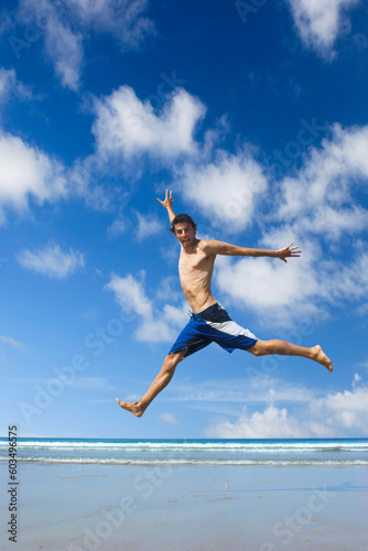 Picture of a young man jumping on the beach