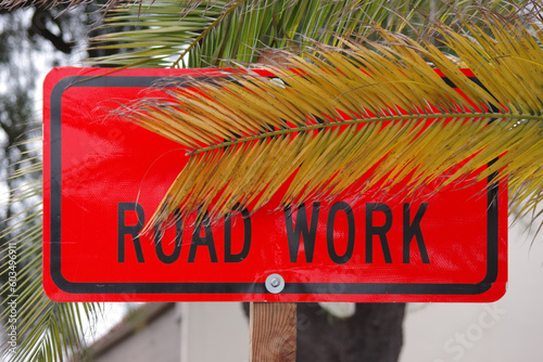 Palm leaf covered ROAD WORK sign