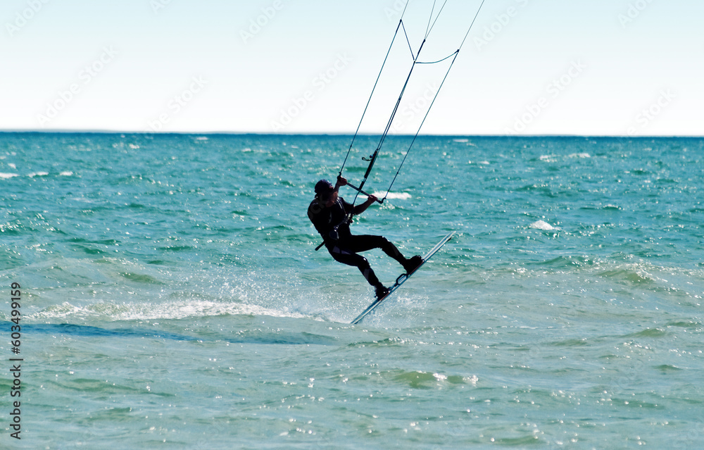 Silhouette of a kitesurfer on waves of a sea