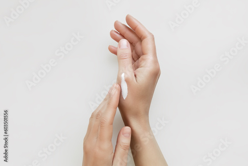 a woman applies a cosmetic cream on her hands. hand skin care concept