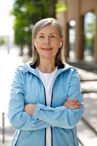 Smiled Mature Woman Looking at the Camera While Listen to Music Using Eeadphones. Sport and Healthy Lifestyle Concept