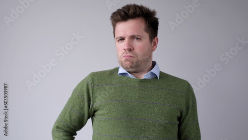 European, young man, shakes his head in disbelief and looks skeptically into the camera