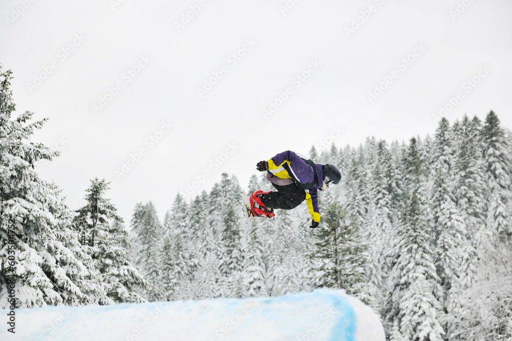 young boys jumping in air ind showing trick with snowboard at winter season young boys jumping in air ind showing trick with snowboard at winter season