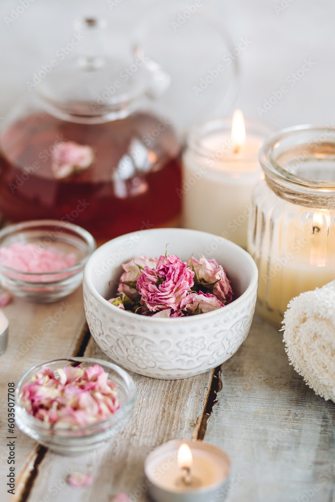 Aromatherapy. Bath salt, pure natural essential oils, floral rose extract. Spa treatment, skin care, relaxation with burning candles, herbal organic hot tea. Towel, wooden background Aromatherapy. Bath salt, pure natural essential oils, floral rose extract. Spa treatment, skin care, relaxation with burning candles, herbal organic hot tea. Towel, wooden background