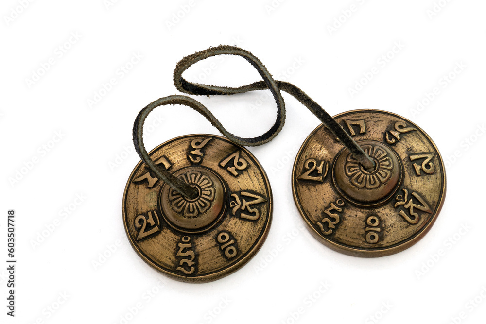 Tibetan Buddhist tingsha (tibetan cymbals) with leather strap isolated on white.