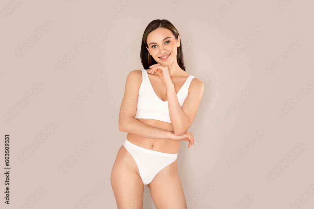 Beautiful young european woman posing on beige, wearing underwear