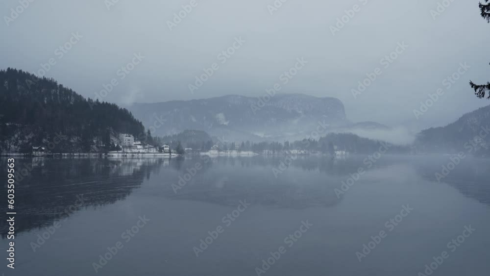 Looking across frozen Lake Bled at snowy mountains in clouds Looking across frozen Lake Bled at snowy mountains in clouds