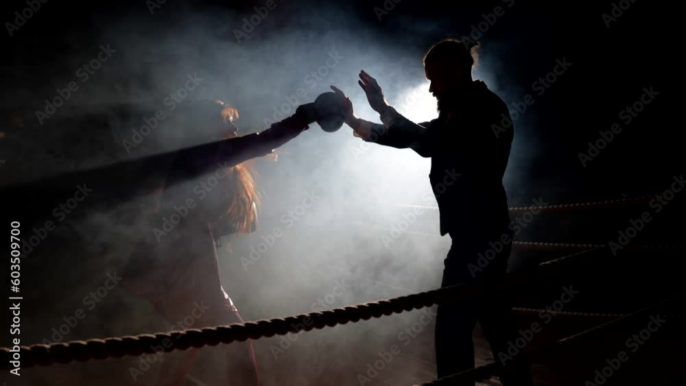 lady boxing with man on ring, silhouette in darkness, concept of relationship, complicated love lady boxing with man on ring, silhouette in darkness, concept of relationship, complicated love