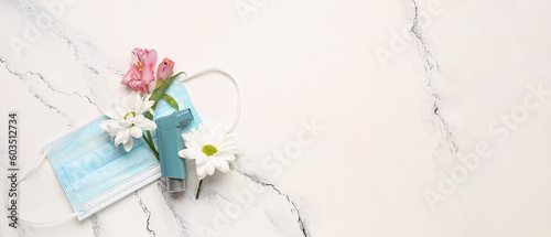 Asthma inhaler, flowers and medical mask on light background with space for text