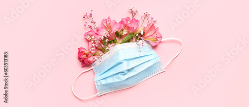 Medical mask and flowers on pink background. Allergy concept