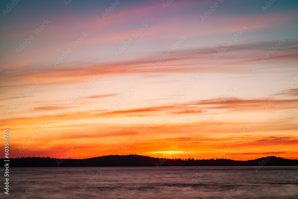 Obraz premium Sunset on the shores of Vancouver Island. Orange and dark tones of the landscape make this sunset timeless. Tofino, Vancouver Island, British Columbia State, Alberni - Clayoquot Regional District.