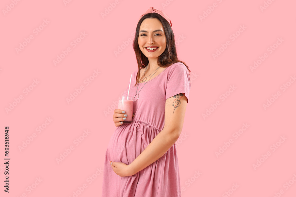 Young pregnant woman with glass of smoothie on pink background Young pregnant woman with glass of smoothie on pink background