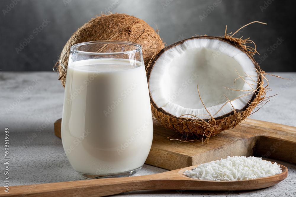 Glass of coconut milk with pieces of coconut on the table. Glass of coconut milk with pieces of coconut on the table.