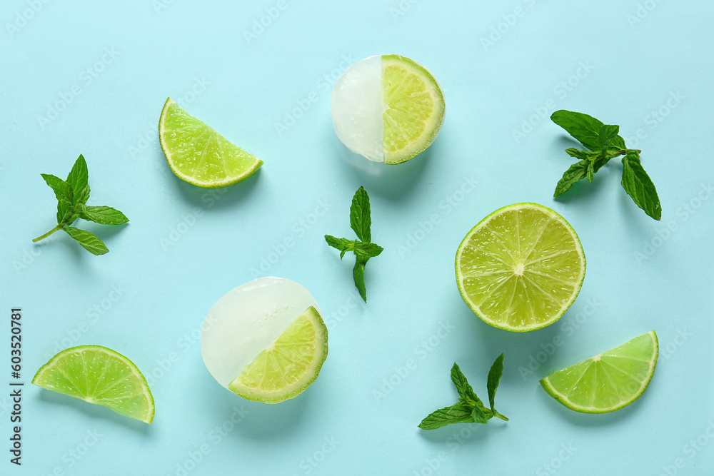 Fresh lime and slices frozen in ice with mint on blue background