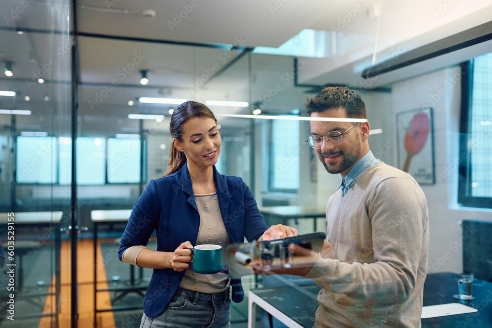 Obraz premium Young colleagues cooperating while working on touchpad in office.