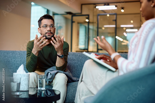Foto Sad man having counseling with psychotherapist at mental health center
