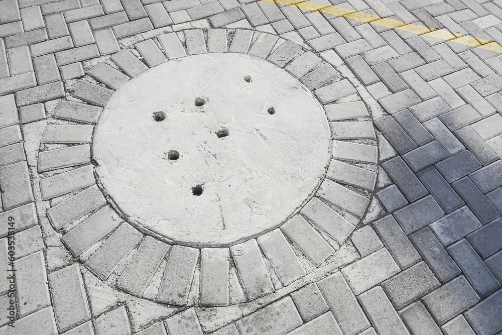 Cement water drainage holes installed in paving block areas to reduce the volume of rainwater on the streets. Concept for protection flood mitigation, architecture, water flow system, plumbing. Cement water drainage holes installed in paving block areas to reduce the volume of rainwater on the streets. Concept for protection flood mitigation, architecture, water flow system, plumbing.