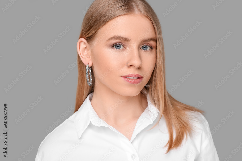 Beautiful young woman with elegant earrings on gray background Beautiful young woman with elegant earrings on gray background