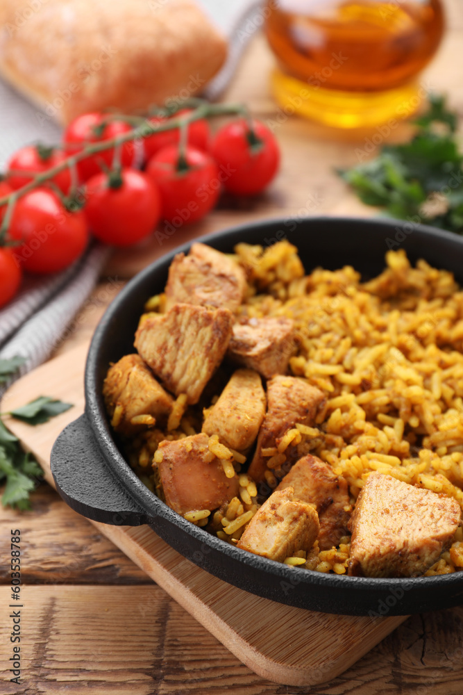Delicious rice with chicken served on wooden table Delicious rice with chicken served on wooden table