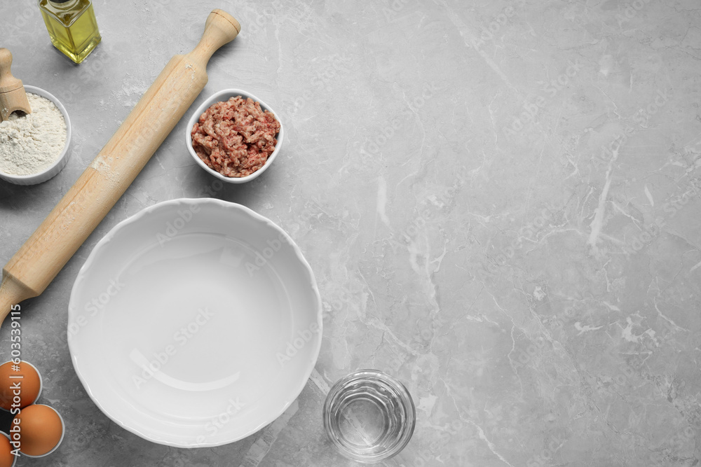 Bowl and different products on grey table, flat lay. Space for text