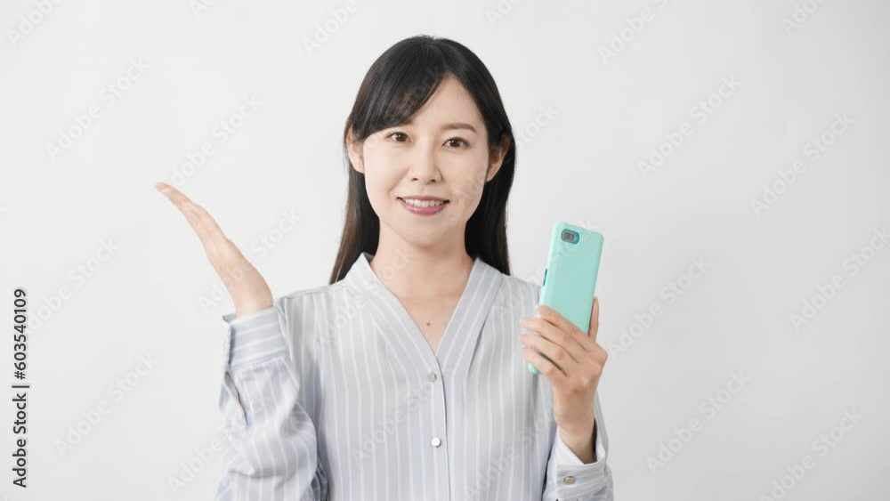 スマートフォンを持ちながら案内をする若い女性 スマートフォンを持ちながら案内をする若い女性
