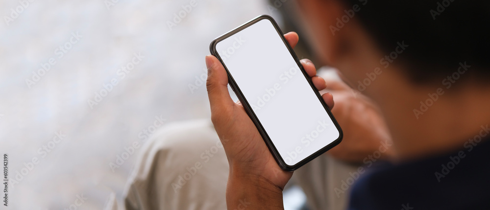 Man holding smartphone with blank screen and left side with empty space for your advertise or text message.