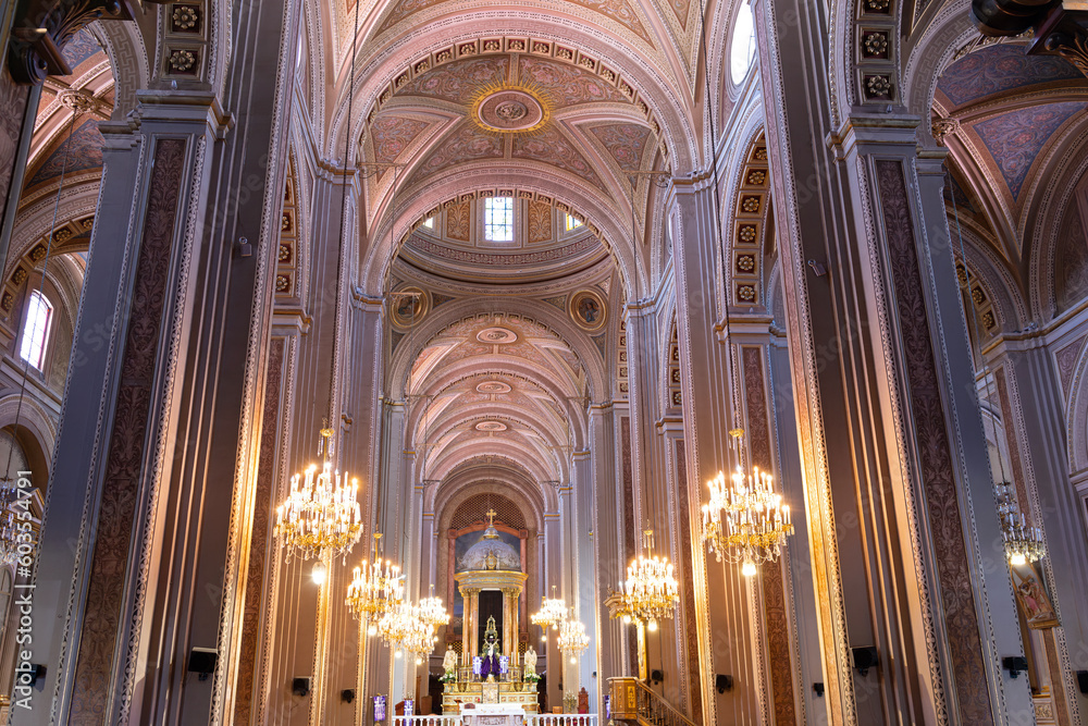 ornate interior of landmark morelia cathedral in baroque architectural style and soaring vaulted ceilings leading to altar at end of nave