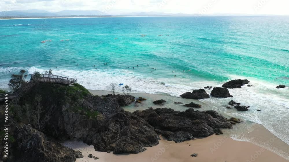 Aerial fly over The Pass lookout at Byron Bay with a view over the surfers in the ocean. Aerial fly over The Pass lookout at Byron Bay with a view over the surfers in the ocean.