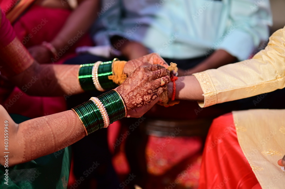 hands of indian wedding.Hindu Bride Wearing Turmeric Thread on a Groom