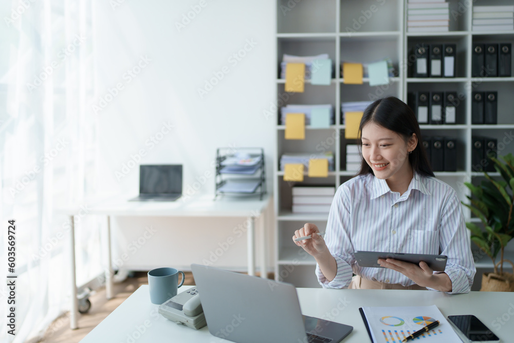 Consultant, advisor, Asian business woman working on the tablet computer work financial and marketing business plan to increase company profits, ready to use computer and marketing planning documents