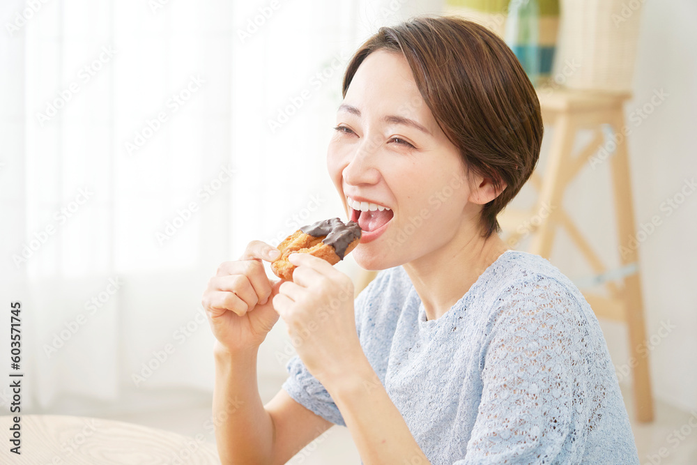 自宅でドーナツを食べる女性 自宅でドーナツを食べる女性