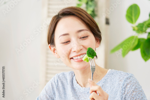 自宅でブロッコリーを食べる女性