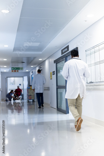 Diverse doctors and patient in busy hospital corridor, with copy space