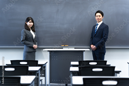 学校の黒板の前に立つ2人の先生