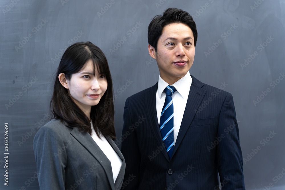 学校の黒板の前に立つ2人の先生 学校の黒板の前に立つ2人の先生