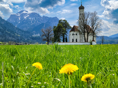 Meadow and beautiful old church in Bavaria with Neuschwanstein Castle and Bavarian Alps in distance - Fussen, Germany	 photo