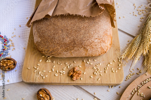 The ancestral bread of Seferihisar, Cittaslow city of Izmir, is made of Karakilcik Wheat in paper bag designed on wooden table wheat ears photo