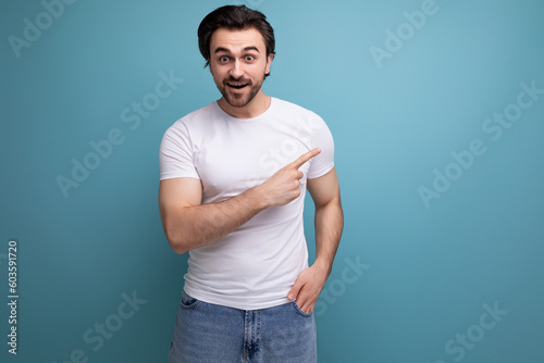 excited brunette man in white t-shirt and jeans pointing finger