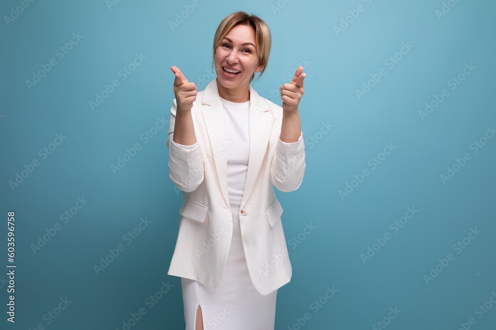 young confident pretty slim blond boss woman in an elegant jacket and dress on a blue background with copy space young confident pretty slim blond boss woman in an elegant jacket and dress on a blue background with copy space