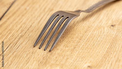 Fork on the wooden table, closeup shot, shallow depth of field