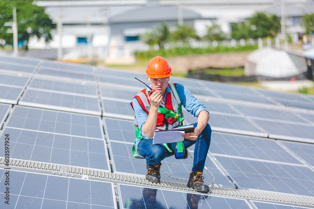 Male professional engineer installing solar photovoltaic panel system, Electrician mounting blue solar module technology on power industrial factory roof, Alternative energy ecological technician job Male professional engineer installing solar photovoltaic panel system, Electrician mounting blue solar module technology on power industrial factory roof, Alternative energy ecological technician job